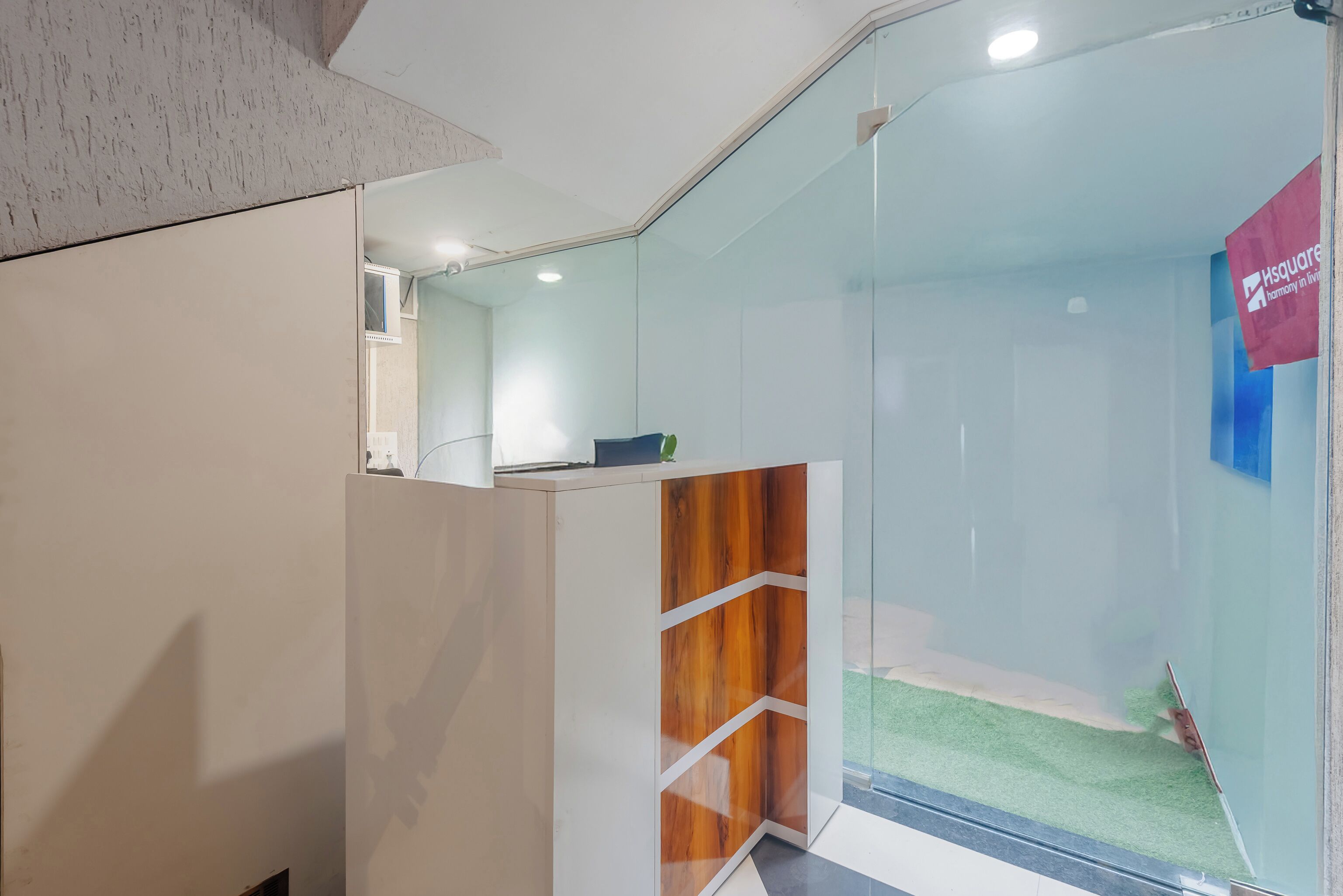 A reception area with a glass partition, a reception desk, and a sign for 'Isquare.'