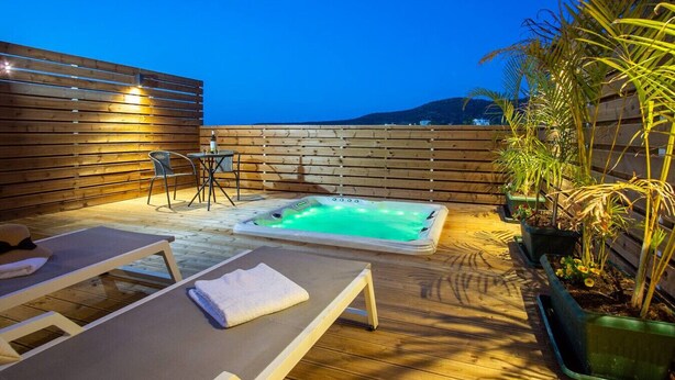 A rooftop terrace with a hot tub, lounge chairs, and potted plants. - Sweet Sissi 2BR Residence with Jacuzzi Sleeps 6 (Sisi)