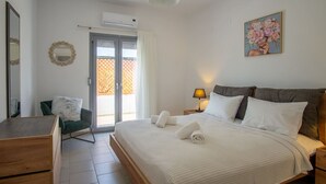 A bedroom with a bed, a chair, a desk, and a painting. - Sweet Sissi 2BR Residence with Jacuzzi Sleeps 6 (Sisi)