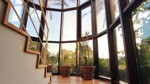 Ein modernes Interieur mit einer geschwungenen Treppe, großen Fenstern und Korbwäschekörben.