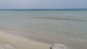 Ein Strand mit klarem Wasser und einem sandigen Ufer.