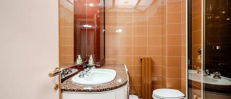 A bathroom with a white sink, a mirror, and a toilet.