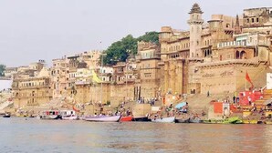 A riverside cityscape with historic buildings and boats.
