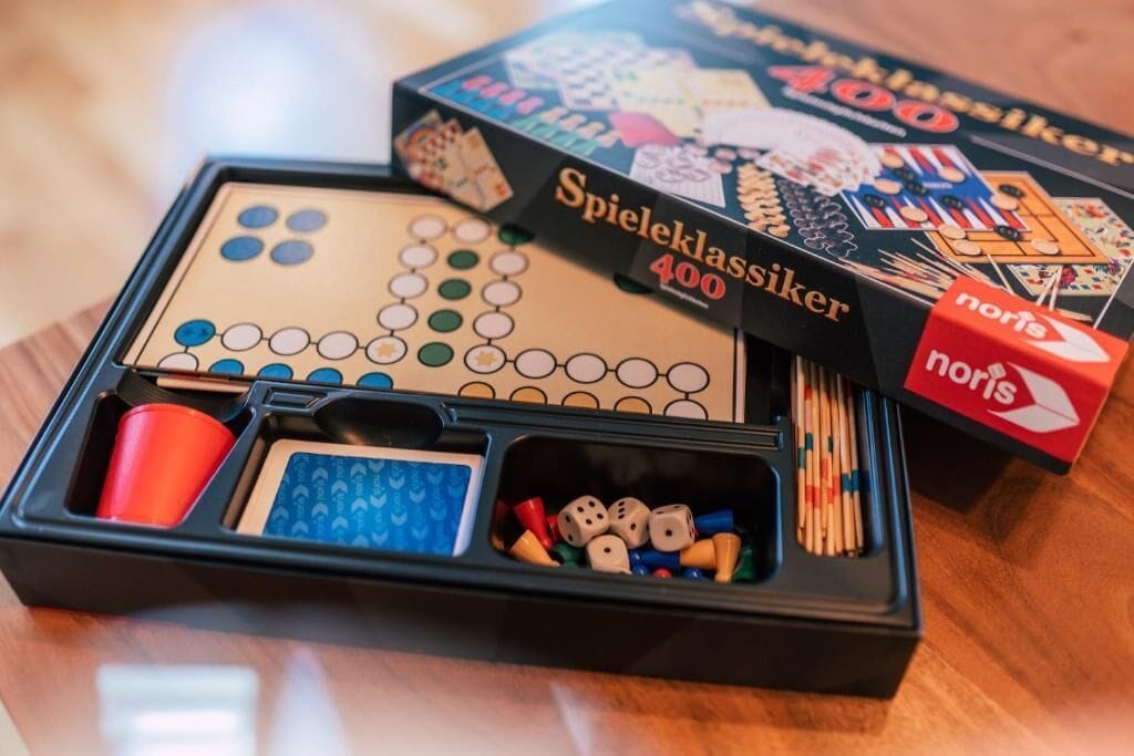 A board game set up on a table, including pieces and a box labeled "Spieleklassiker 400".