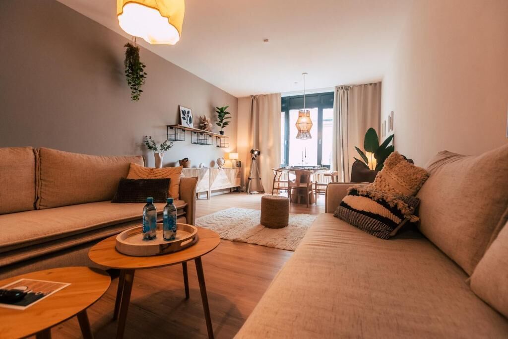 A cozy living room with a sofa, a coffee table, and a dining area with a table and chairs.
