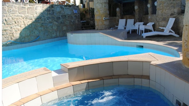 A swimming pool with a hot tub area, stone walls, and white lounge chairs. - Mandurah Crab Fest
Silversands resort  1/bed apartment 
Fully equiped. Max 4 (Mandurah)