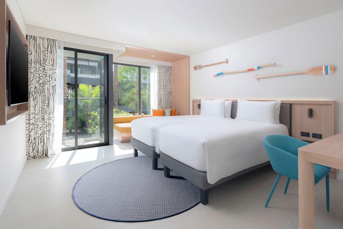 Une chambre d’hôtel moderne avec un grand lit, un bureau et une télévision.
