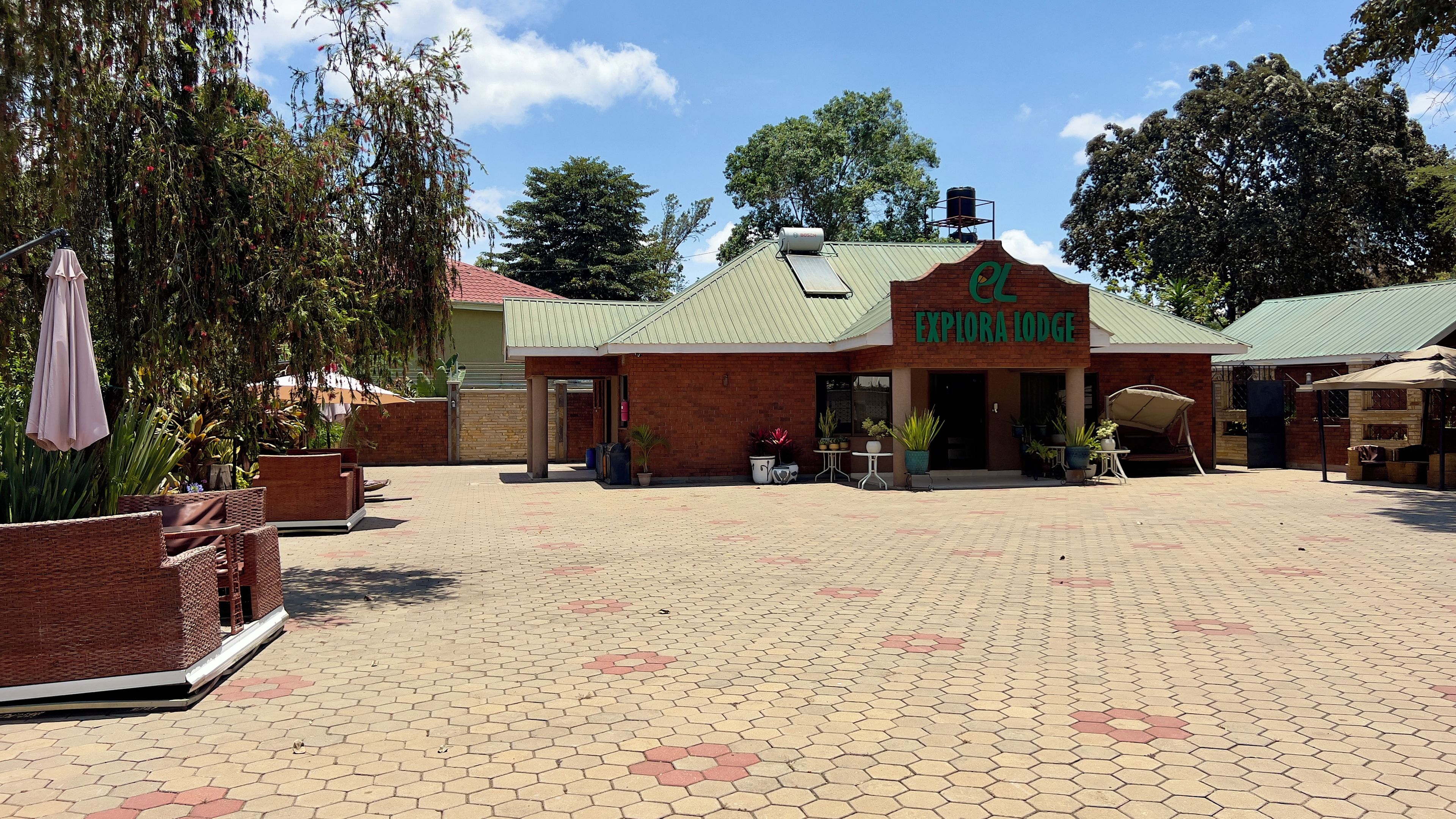 A brick building with a green roof and a sign that reads 'Explora Lodge.'