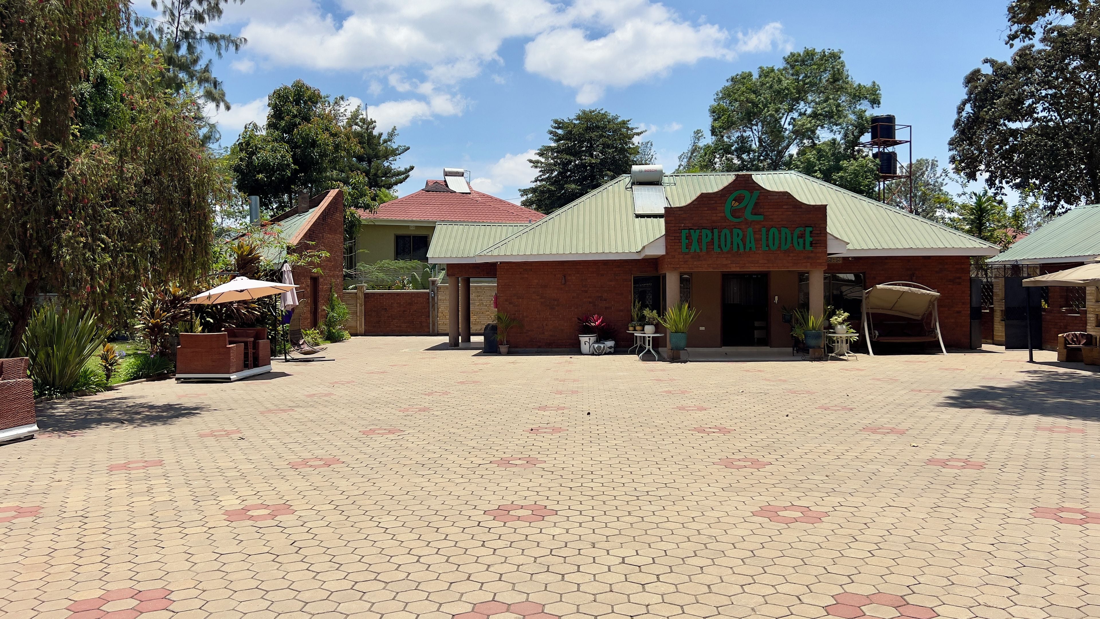 A brick building with a green roof and a sign that reads 'EXPLORA LODGE'.