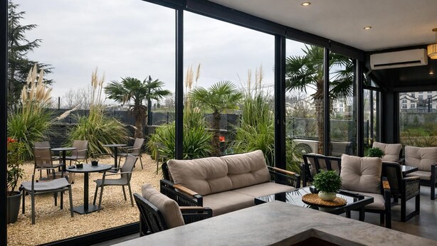 A modern interior with a large glass window, a sofa, and a coffee table. - Luxury 3BR Apartment with Mountain View, AC & Pool – Maşukiye (Kocaeli)