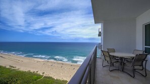 Ein Balkon mit Blick auf Strand und Meer.