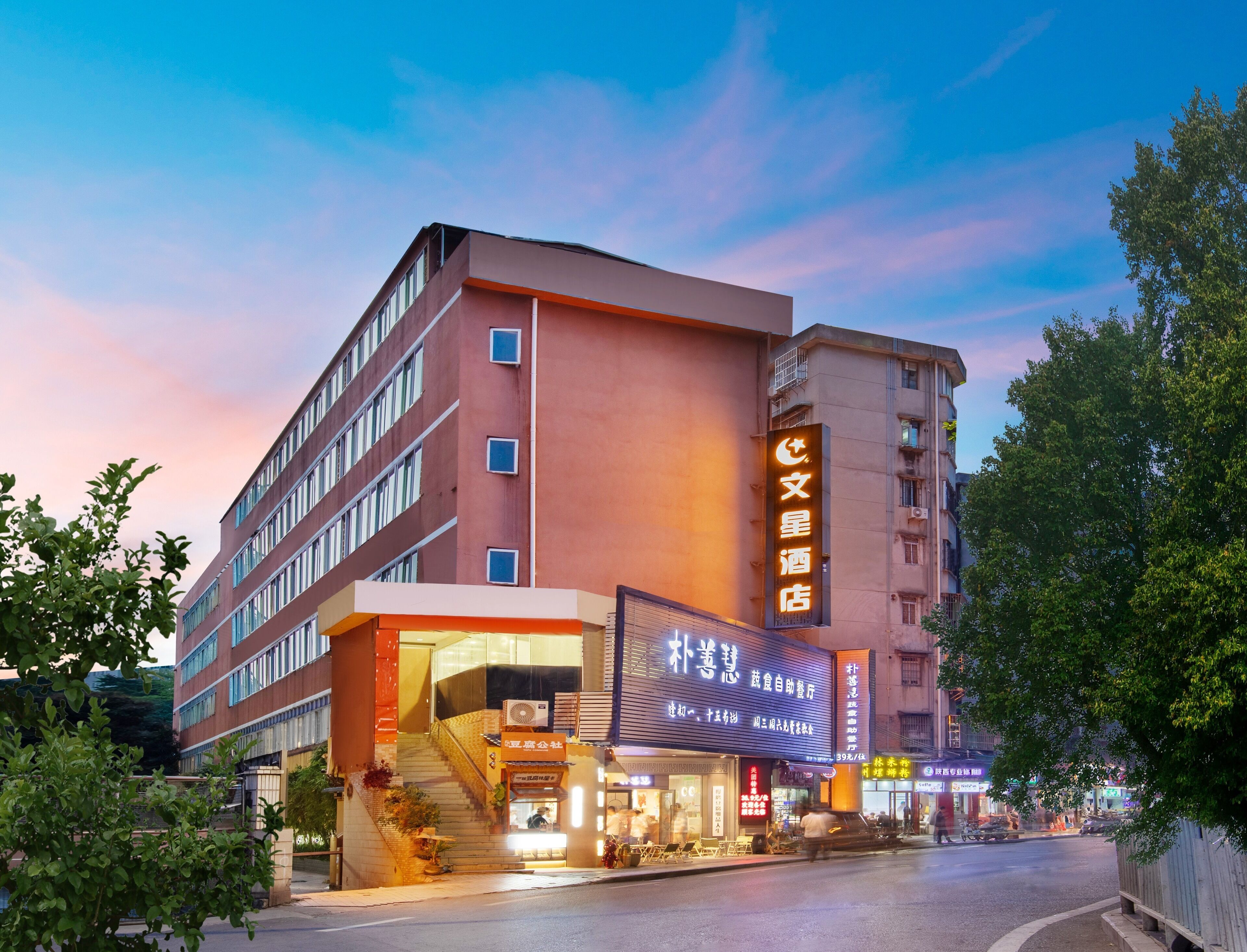 A hotel with a prominent sign, multiple floors, and a staircase leading to the entrance.