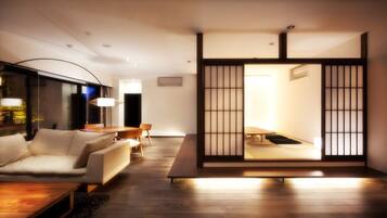 A modern living room with a sofa, coffee table, and dining area.