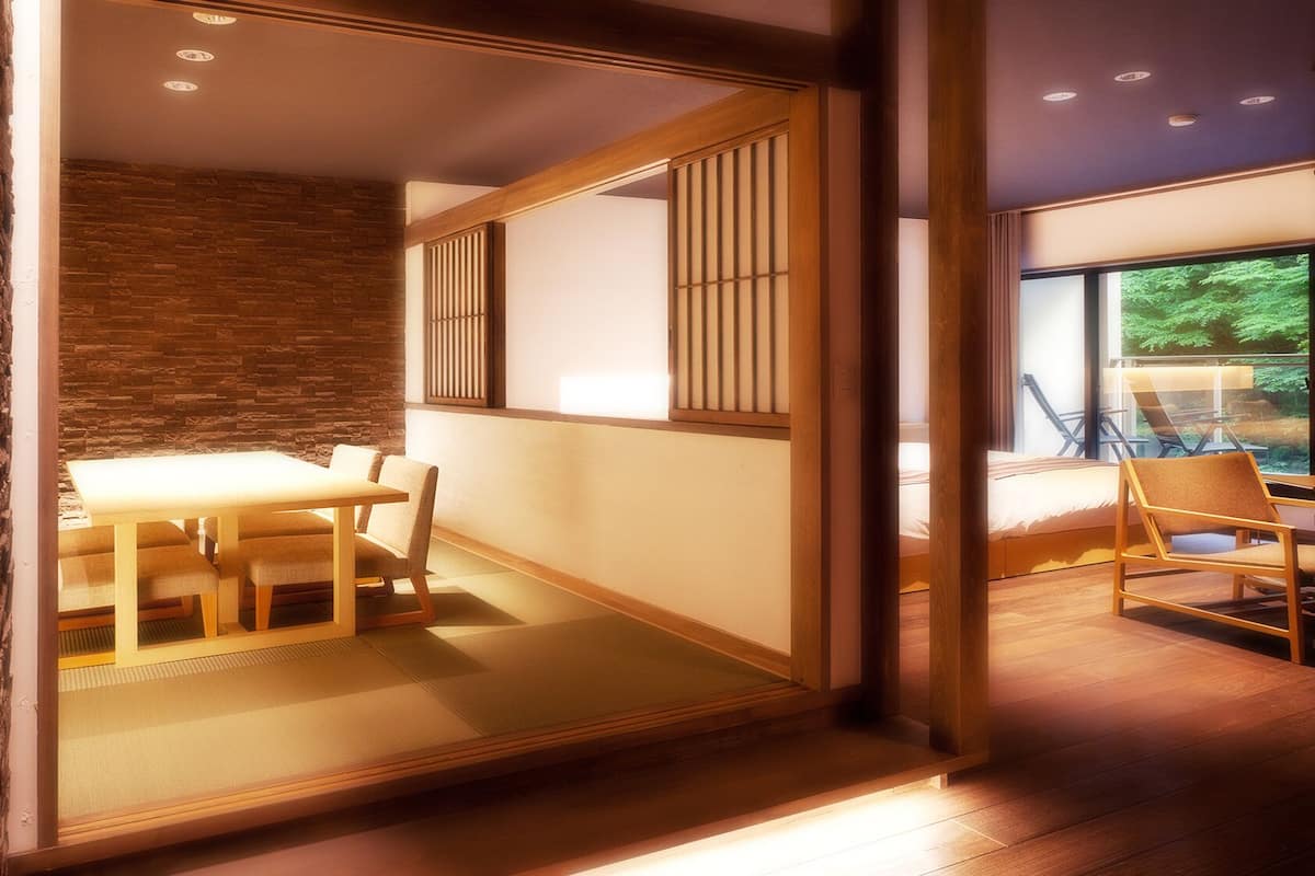 A modern interior with a dining area, a bed, and a view of greenery.