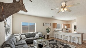 A modern living room with a sectional sofa, a coffee table, and a ceiling fan. - Indulge in this beautiful New Mexico home located in Southwest Albuquerque (Albuquerque)