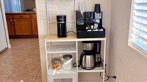 A compact kitchen area with a coffee station, including a coffee maker, cups, and a water dispenser. - Indulge in this beautiful New Mexico home located in Southwest Albuquerque (Albuquerque)