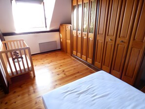 A room with a bed, a wooden crib, a wardrobe, and a window. - Holiday Home "Gîte De La Guillone" with Private Pool, Terrace and Garden (Savignac)