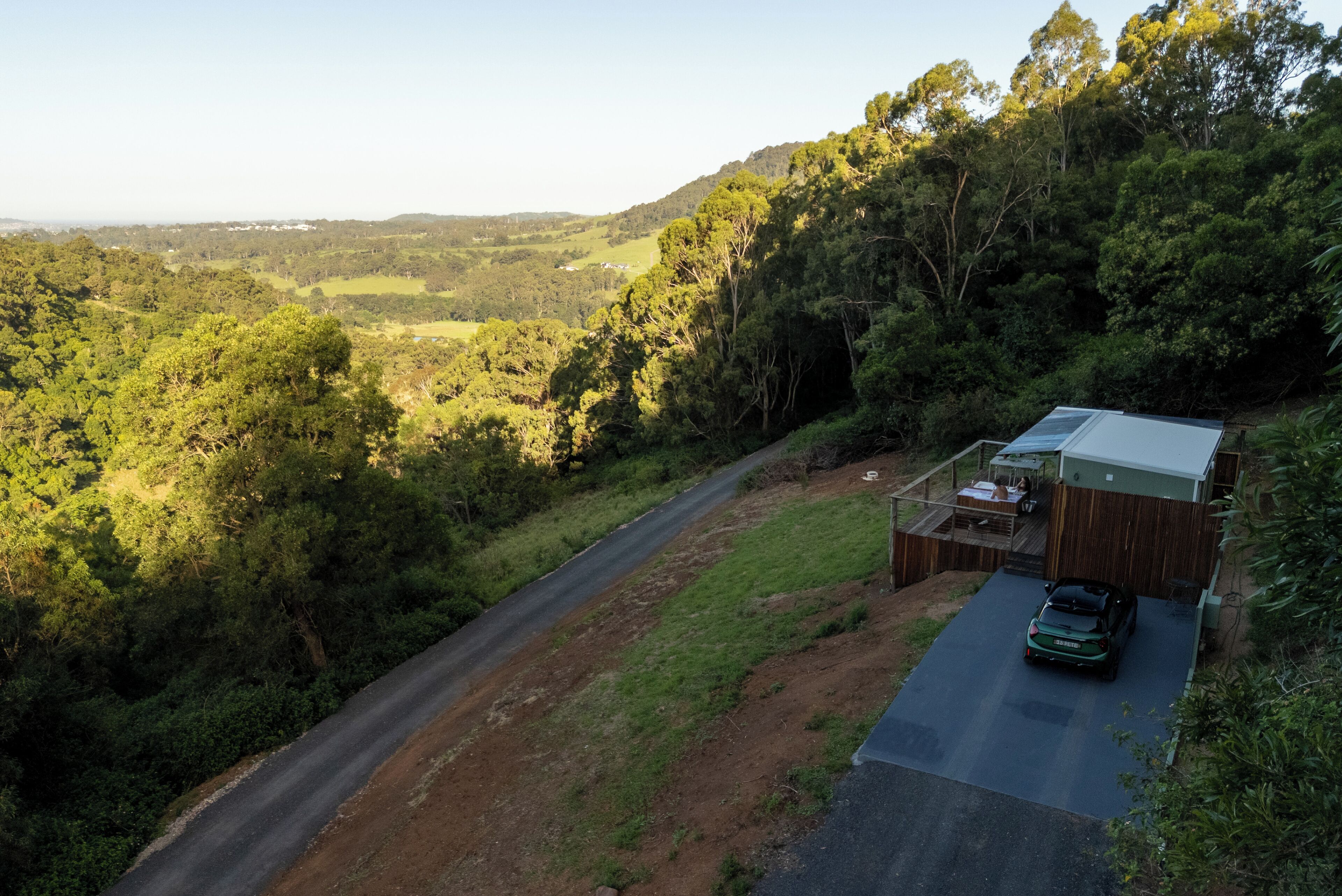 Une maison avec une allée pavée et une voiture garée dans l’allée.