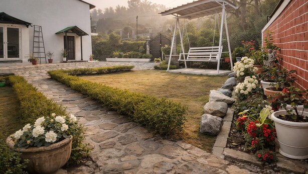 Ein Garten mit einem gepflasterten Weg, einer Schaukel und Kübelpflanzen.
