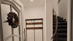 A hallway with a wooden door, a coat rack, and a staircase. - Stylish loft-style apartment & air-conditioned (Plaidt)