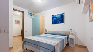 Une chambre à coucher avec un lit, une table de chevet et un tableau accroché au mur.