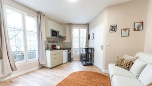 Een modern appartement met keuken, eethoek en zithoek.