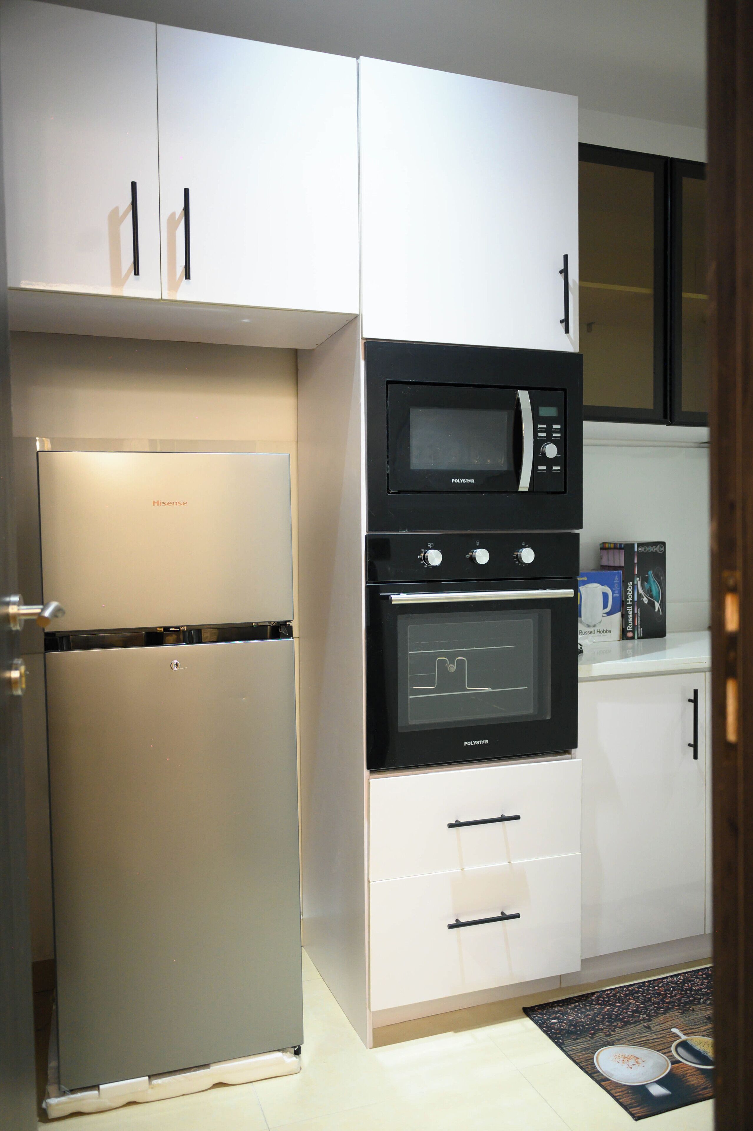 A compact kitchen with a built-in refrigerator, oven, and microwave.