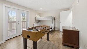 Ein Zimmer mit einer Tischfußballplatte, einem Stockbett und einem kleinen Schrank.