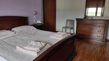 A bedroom with a wooden bed, a dresser, a chair, and a mirror.