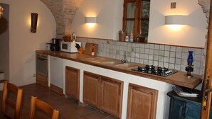 A kitchen with a wooden countertop, a sink, a stove, and cabinets. - Over 1000 year old country house with pool near Uzes for 12 people, ideal for families (Foissac)