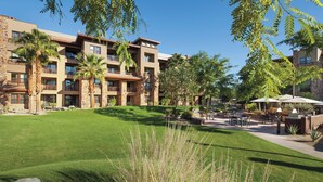 A multi-story hotel with balconies, a well-maintained lawn, outdoor seating, and a patio area. - 1 Bed-room Villa with full kitchen in Palm Desert from 4/7/2026 for 5 nights (Palm Desert)