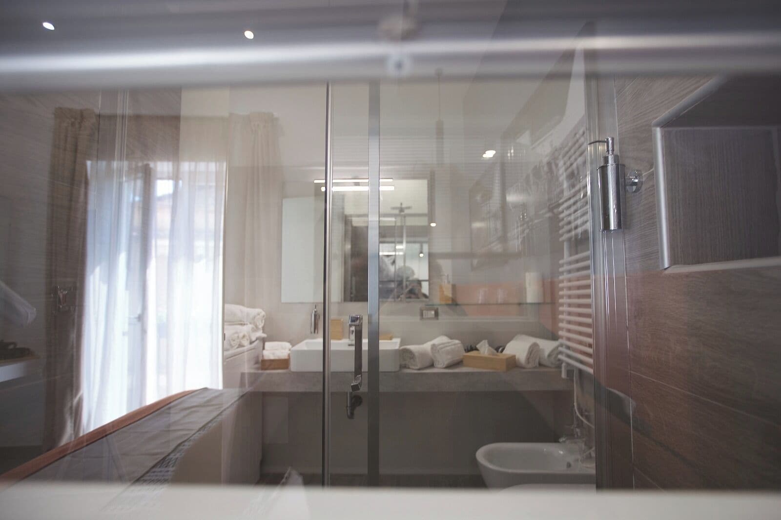 Un baño moderno con cabina de ducha de vidrio, bañera y inodoro.