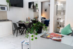 A modern kitchen with a dining area, a living space, and a bathroom.