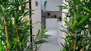 A modern kitchen with white cabinets and a marble countertop. - Scugnizzo Apartment (Naples)
