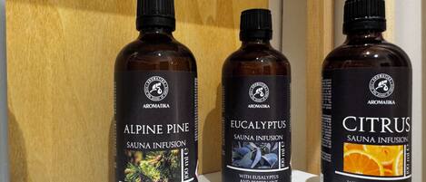Three bottles of essential oils labeled Alpine Pine, Eucalyptus, and Citrus on a shelf.