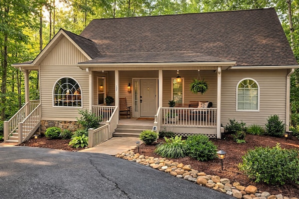 A two-story house with a front porch, a staircase, and a driveway.