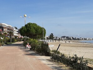 A coastal promenade with a paved walkway, a tree-lined path, and a beach in the background. - Mini Penthouse (3-Bedroom), Garage, and Beachfront Building (La Baule-Escoublac)
