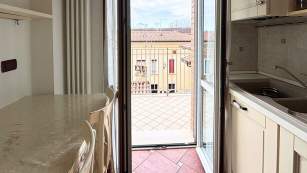 Eine Küche mit Blick auf einen Innenhof, einer Schiebetür und einem gefliesten Boden.