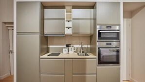 Eine kompakte Küche mit integrierten Geräten, darunter Mikrowelle, Backofen und Spüle.