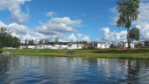 Vue sur un lac, avec des maisons mobiles et une table de pique-nique au bord de l’eau.