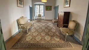 A hallway with a patterned carpet, wooden furniture, and framed artwork. - Pavillon de l'Orangerie room (La Ferté-Saint-Aubin)