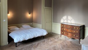 A bedroom with a bed, dresser, and two wall-mounted lights. - Pavillon de l'Orangerie room (La Ferté-Saint-Aubin)