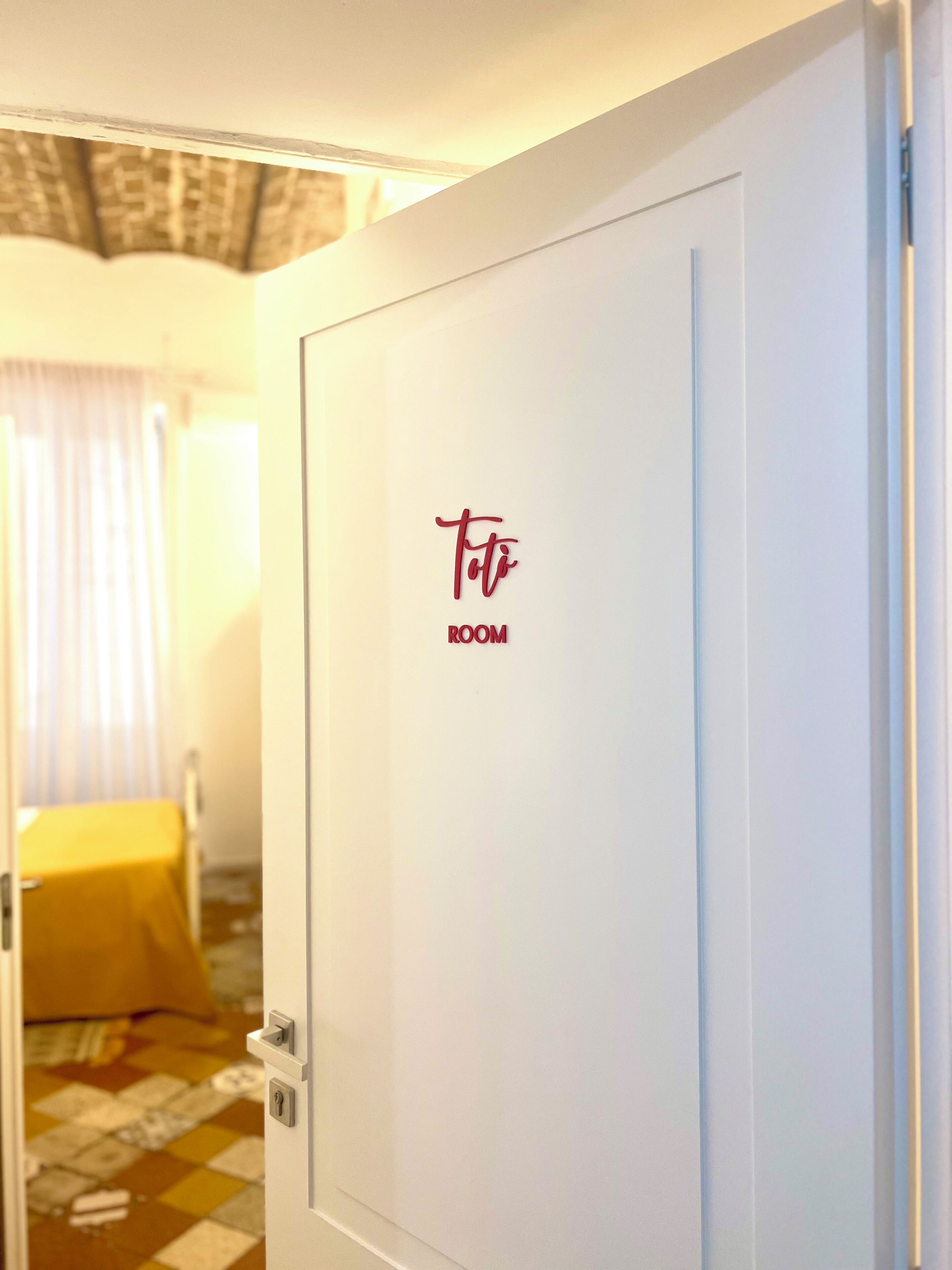 A hotel room door with a sign reading "Toto ROOM".