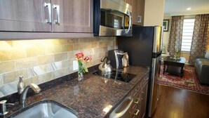 Eine moderne Küche mit Granit Arbeitsplatten, Edelstahlgeräten und Holzschränken.