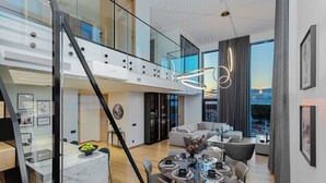 Un interno moderno con zona pranzo, una scala e vista sulla città.