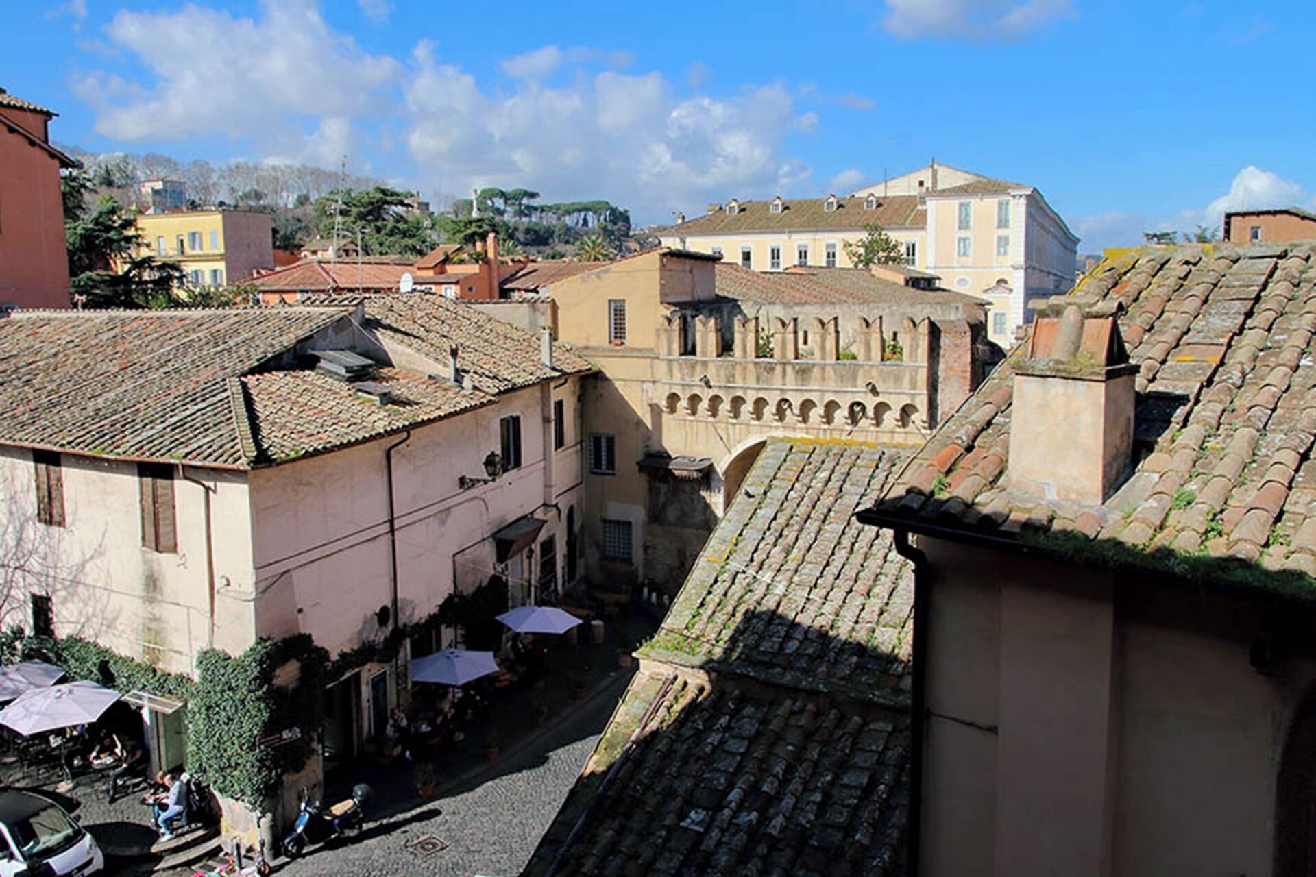 A historic town square with traditional buildings, a central open space, and a cobblestone street.
