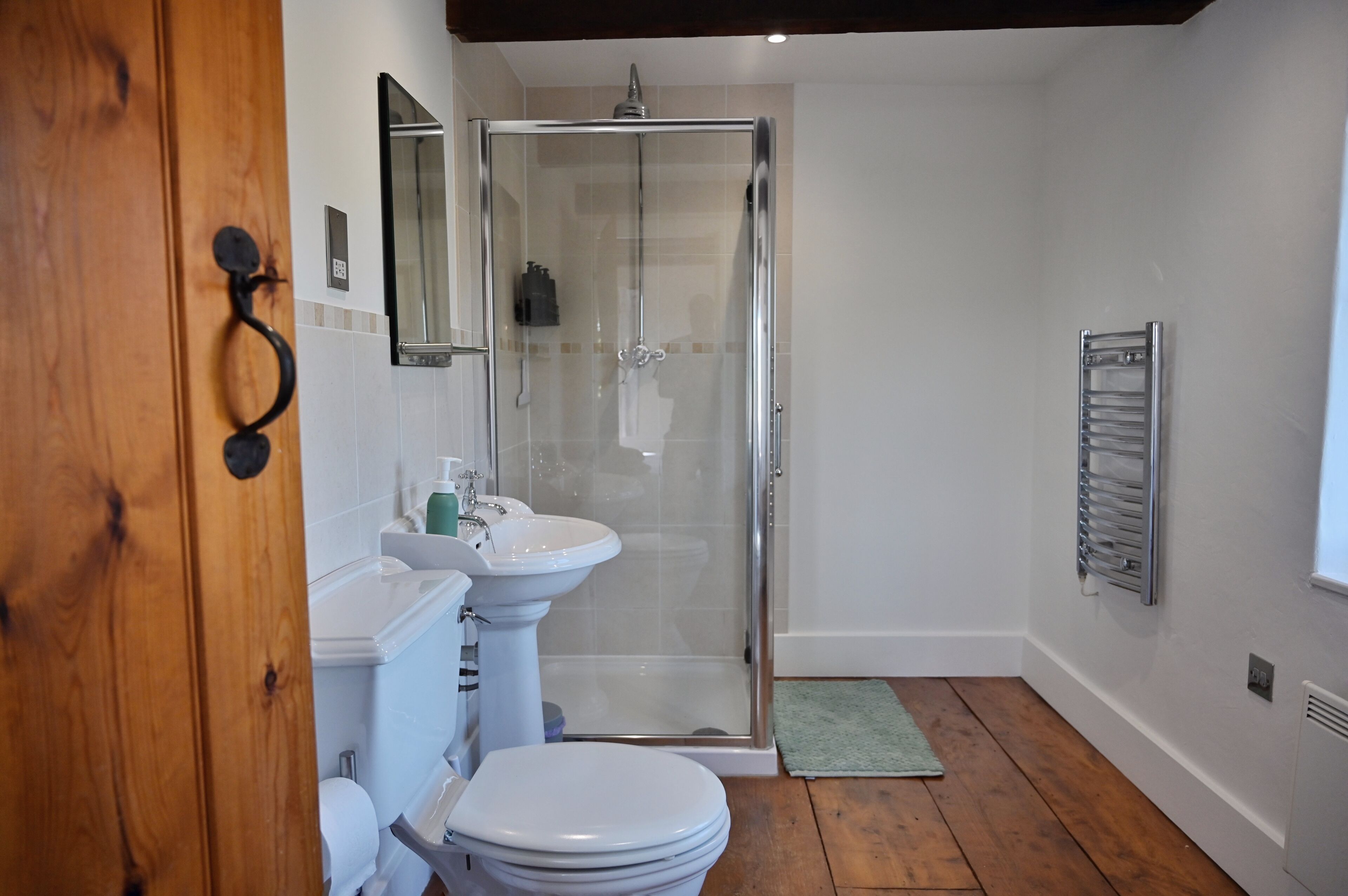 Une salle de bain avec une douche à parois de verre, un lavabo blanc et des toilettes.