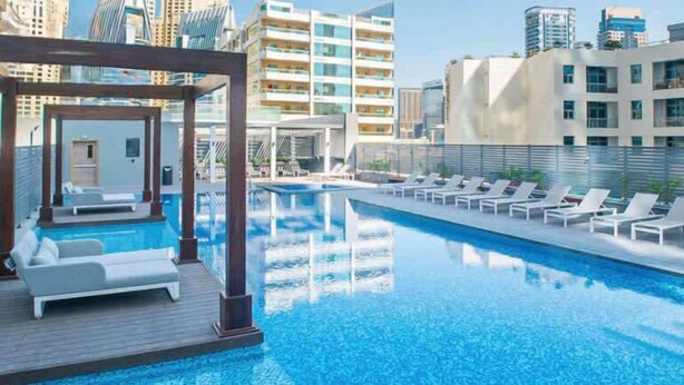 A rooftop pool with lounge chairs and a cabana. - StayShort - Studio in Marina that Sleeps 3 with a Perfect City View (Dubai Marina)