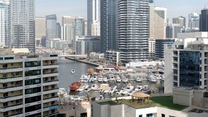 A marina with numerous boats docked, surrounded by high-rise buildings and a river. - StayShort - Studio in Marina that Sleeps 3 with a Perfect City View (Dubai Marina)