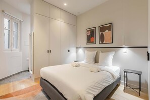 A modern bedroom with a large bed, a wardrobe, and two framed artworks on the wall. - Charming - Air-conditioned and Terrace (Paris)